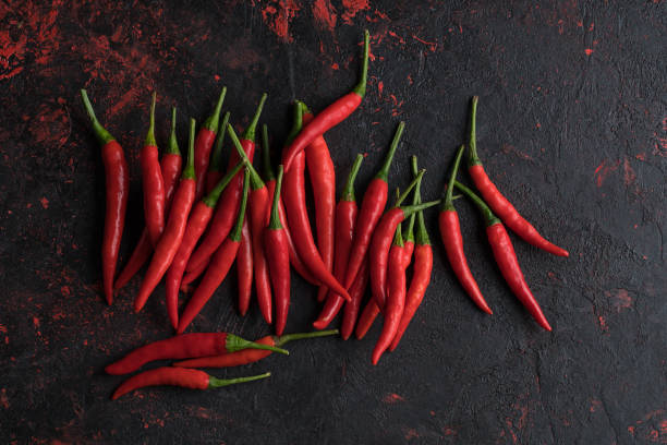istock Red hot chili peppers on old wooden table with place for text 1023136146