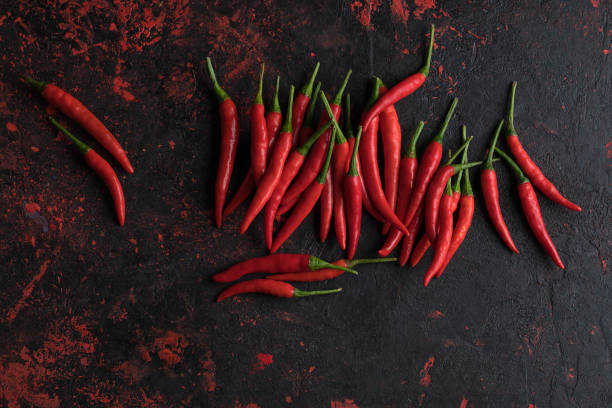 istock Red hot chili peppers on old wooden table with place for text 1023136290