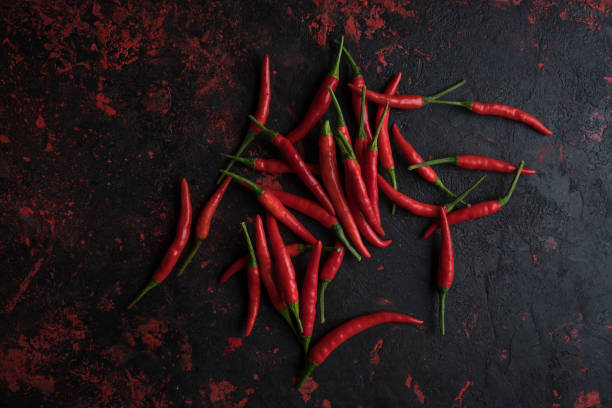 istock Red hot chili peppers on old wooden table with place for text 1023138988
