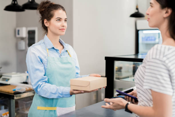istock Shopkeeper Handing Box to Customer 1023139388
