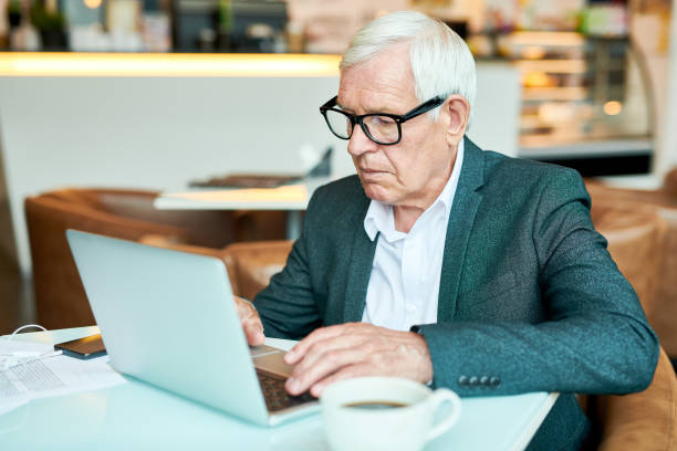 istock Senior Businessman Using Laptop in Cafe 1023140400