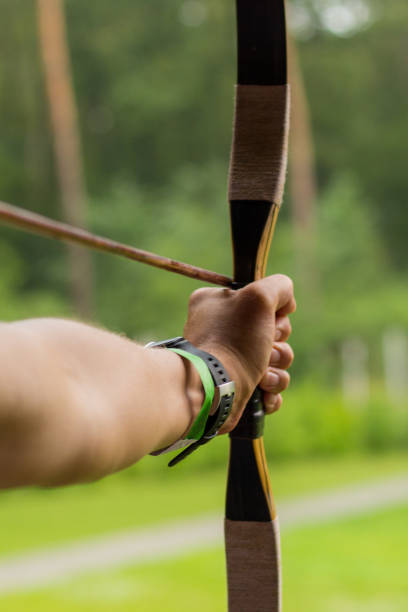 istock Aiming archers hand on the green background. 1023145392