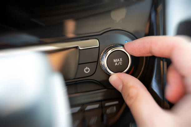 istock Man turning on car air conditioning system 1023159944