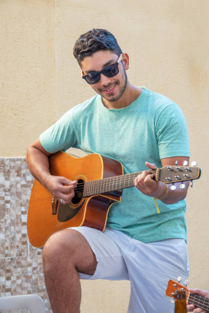 istock Young brazilian man playing the guitar 1023160260