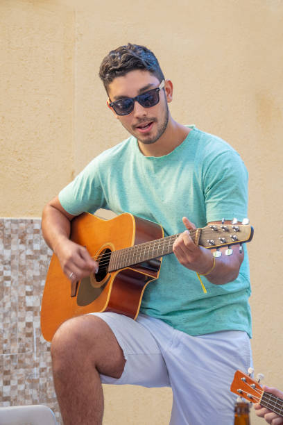 istock Young brazilian man playing the guitar 1023160310