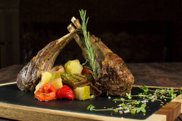 istock Lamb ribs grilled on cutting board with roasted vegetables. 1023167886
