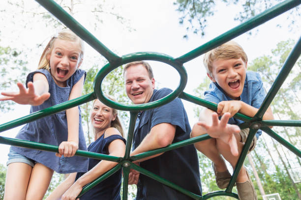 istock Family on playground looking through monkey bars 1023179362