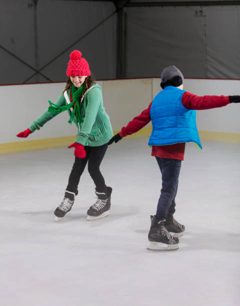 istock Two children, siblings, skating at ice rink 1023194370