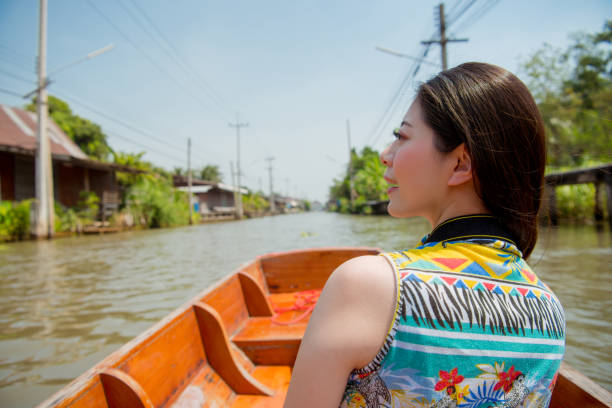 Young woman sitting on the boat and enjoying the good weather. Concept about boat and sightseeing tour, happiness, traditional architecture and culture.