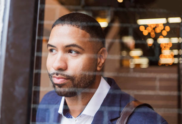 Mixed race man leaving work, looking through glass door