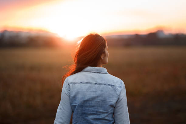 istock Woman walking towards sunset 1023211814