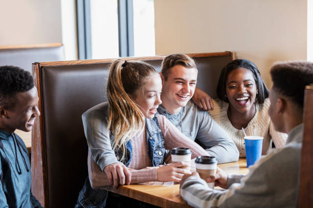 istock Five teenagers sitting in restaurant booth, conversing 1023212014