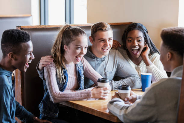 istock Five teenagers sitting in restaurant booth, conversing 1023212064