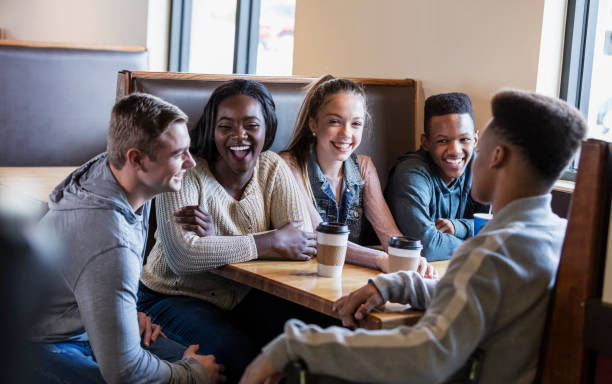 istock Five teenagers sitting in restaurant booth, conversing 1023212100