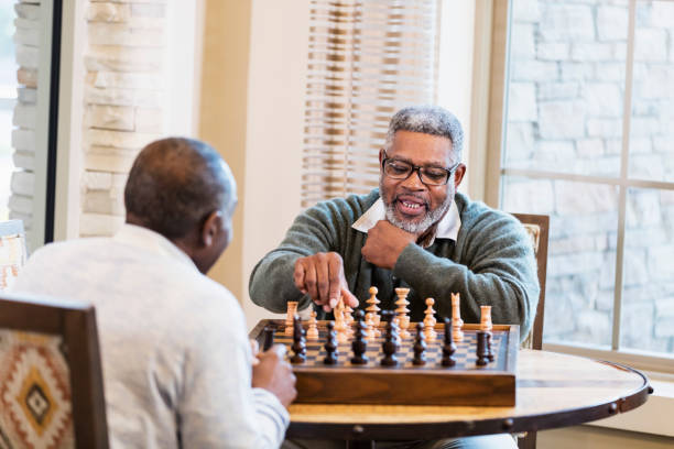 istock Senior African-American man and friend  playing chess 1023214624