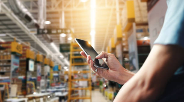 istock Factory worker using application on mobile smartphone to operate automation for modern trade. Checking order in large warehouse. Import and export the shipping cargo. 1023224312