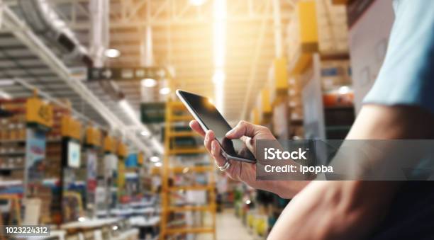 Factory Worker Using Application On Mobile Smartphone To Operate Automation For Modern Trade Checking Order In Large Warehouse Import And Export The Shipping Cargo Stock Photo - Download Image Now