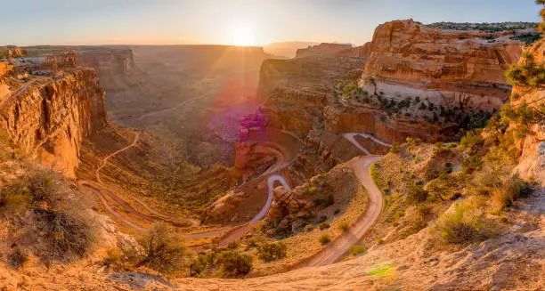 Dirt road winding down the face of a cliff at sunrise