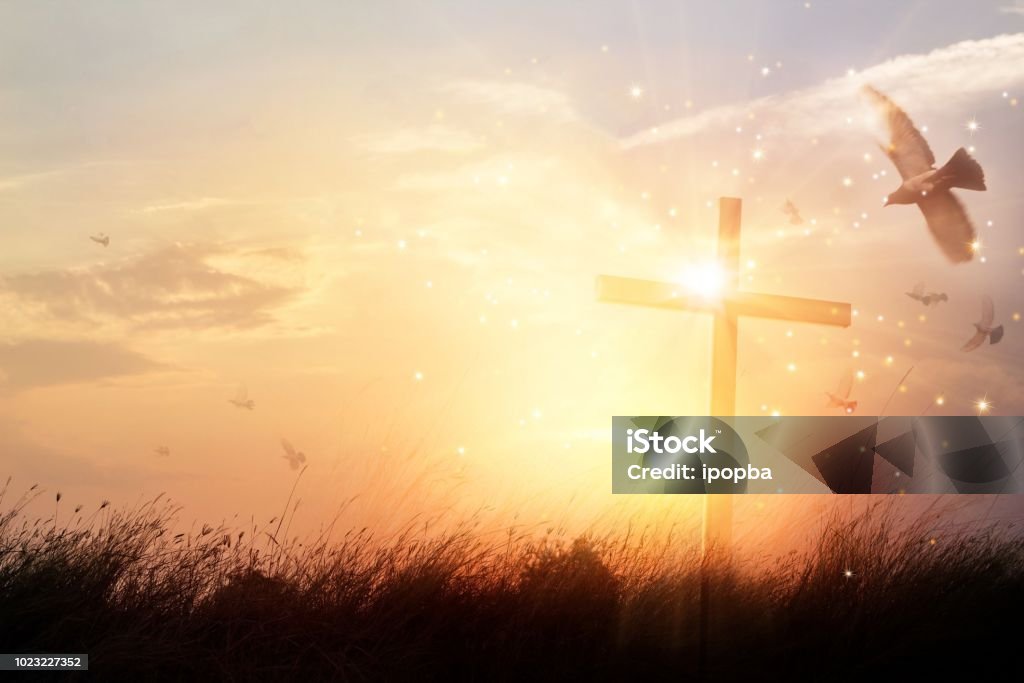 Silhouette christian cross on grass at sunrise background with miracle bright lighting, religion and worship concept Spirituality Stock Photo