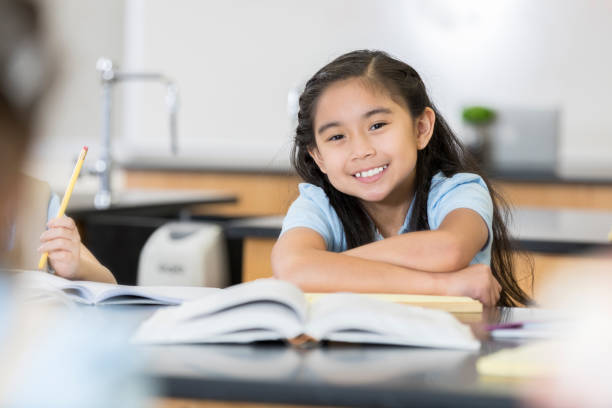 istock Adorable middle schoolgirl smiles for camera in science class 1023229650