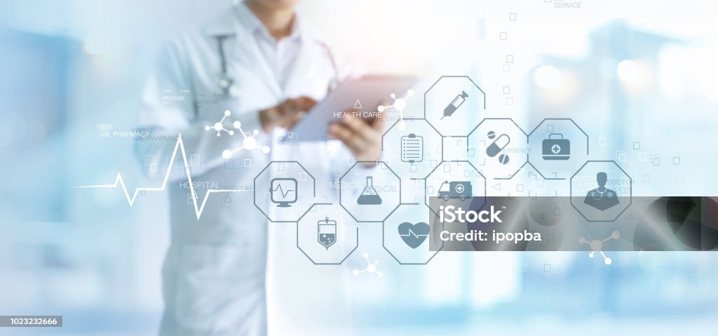 Medicine doctor with stethoscope using tablet and medical icon network connection on virtual screen interface in hospital background. Modern medical technology concept. Healthcare And Medicine Stock Photo