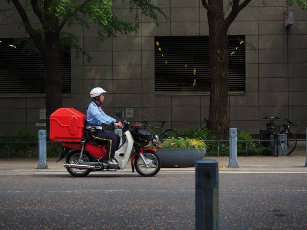 赤いバイクとポスト役員みなとみらい地区の風景 - postal worker ストックフォトと画像