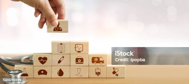 Health Insurance Concept Hand Of Medicine Doctor Holding Wood Block And Stacking Up Icon Healthcare Medical And Stethoscope On Backgroud Stock Photo - Download Image Now