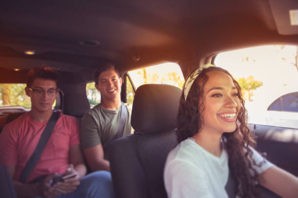 Ride Sharing Young 20 somethings riding together in a car. car pooling stock pictures, royalty-free photos & images
