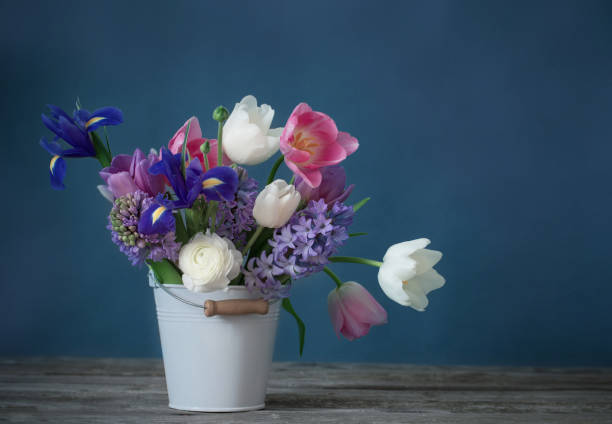 istock spring flowers in bucket on gray background 1023297732