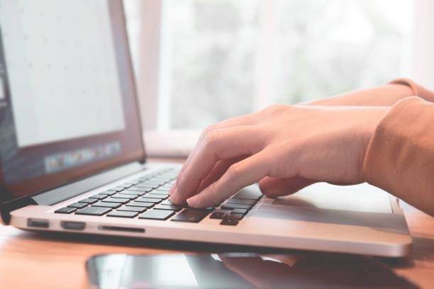 istock Closeup woman's hands using on a laptop on a wooden desk 1023343316