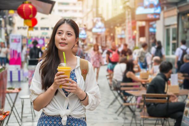 istock woman holding a cup of mango juice 1023343330