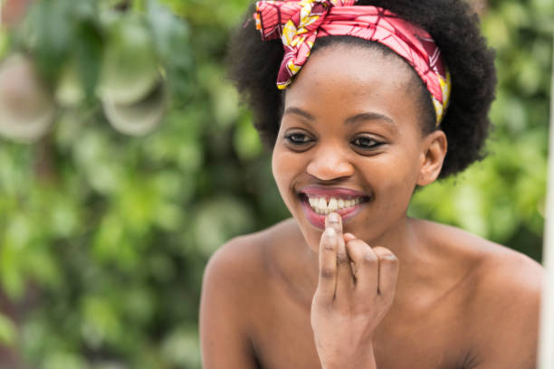 istock Young African woman checking her lipstick 1023343544