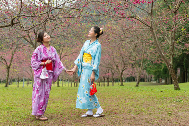 istock woman stand side by side and holds hands together 1023344450