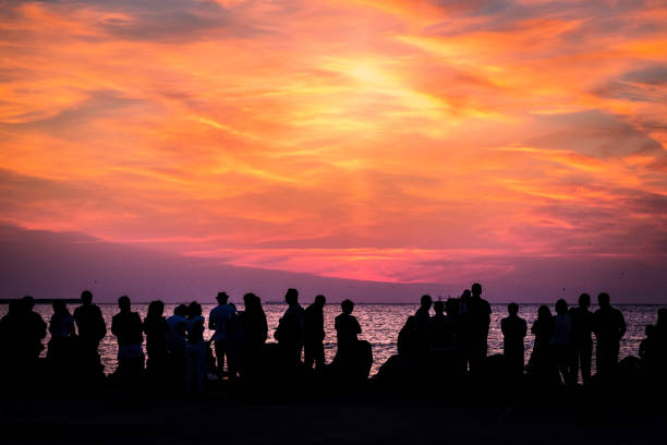 istock Crowd of silhouetted people watching sunrise or sunset 1023356194