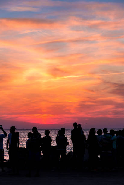istock Crowd of silhouetted people watching sunrise or sunset 1023362016