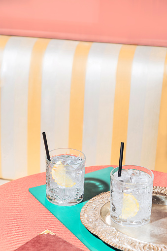 Gin and tonic cocktails on a table, into a pop-colored bar