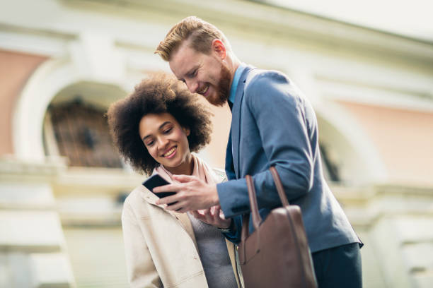 istock Happy business couple using smart phone outdoors 1023371764