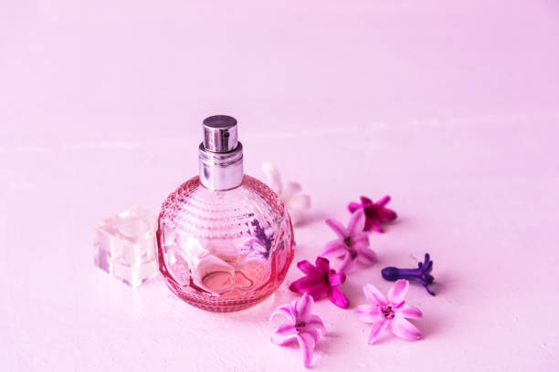 istock Perfume bottles with flowers. Pink background 1023372870