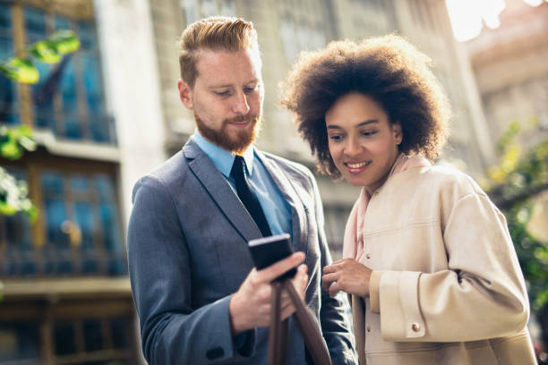 istock Happy business couple using smart phone outdoors 1023378628