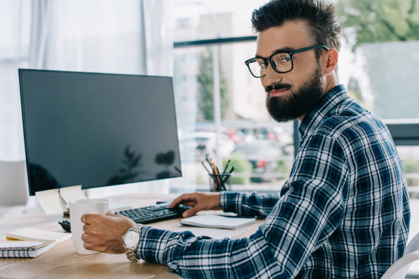istock young successful seo sitting at workplace with blank computer screen and looking at camera 1023378690