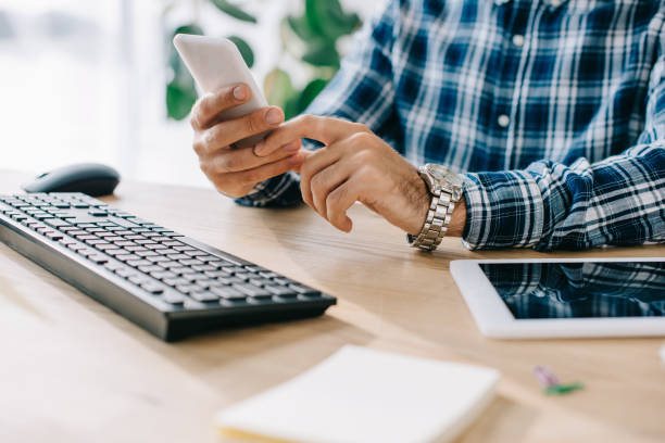 istock cropped shot of businessman using smartphone at workplace 1023378714