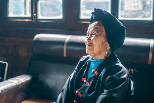 istock old chinese woman sitting on sofa indoors 1023402118