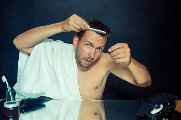 istock Man With Comb Concerned About Hair Loss 1023418194