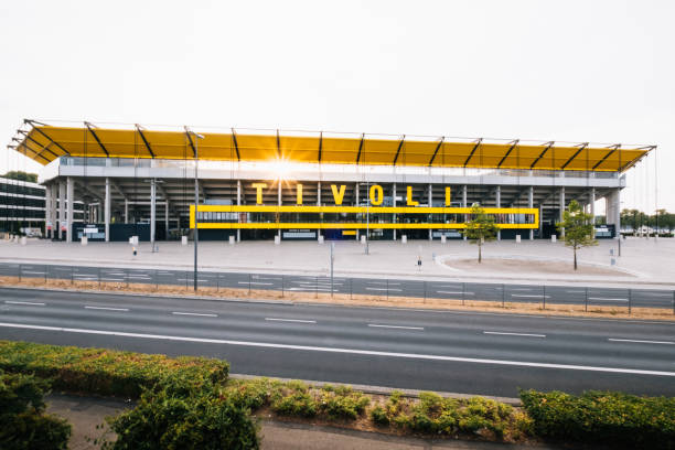 Aachen, Germany - October 04, 2018: Stadium Tivoli in Aachen at sunset (frontal view)\nThe Tivoli is a football stadium in the Sportpark Soers in Aachen, North Rhine-Westphalia. The stadium has a capacity of 32,960 seats and the premises in the Tivoli Business area are suitable for social events, conferences and seminars. Every year, competitions such as the equestrian tournament Chio take place here.