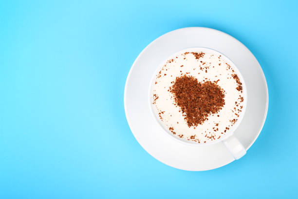 istock Full white cup of cappuccino coffee on blue 1023422782