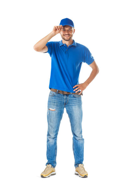 Full length portrait of smiling man in in blue uniform touching his cap in greeting stock photo