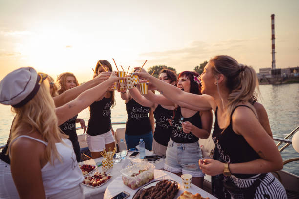 Ladies celebrating bachelorette party Cheerful bride and bridesmaids celebrating hen party on the boat. bachelorette party stock pictures, royalty-free photos & images