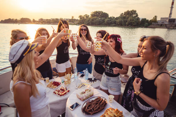 Ladies celebrating bachelorette party Cheerful bride and bridesmaids celebrating hen party on the boat. bachelor and bachelorette parties stock pictures, royalty-free photos & images