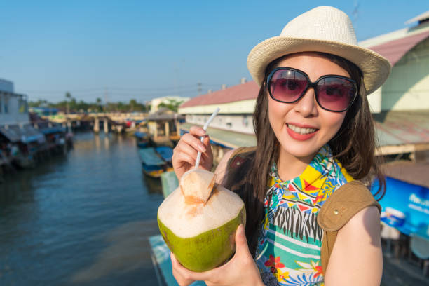 istock woman holding a coconut drink 1023457348