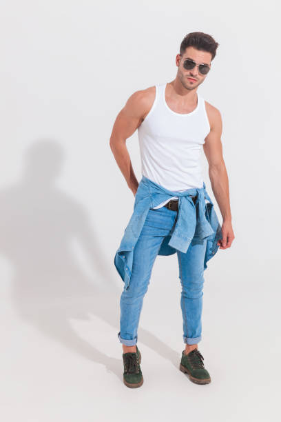 istock sexy fit man wearing undershirt and sunglasses stands in spotlight 1023471904